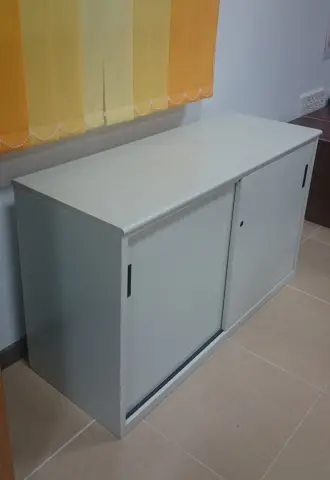Imagen Armario metlico bajo con puertas correderas y estante.